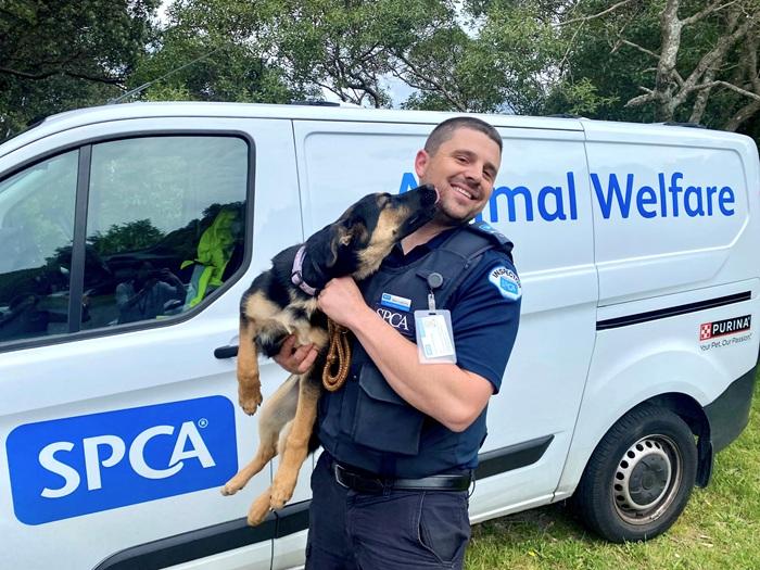 SPCA Inspector Ben holding a happy dog
