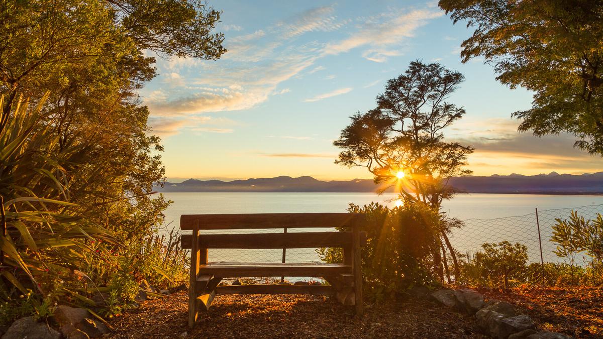 Sunrise seen over the sea from a bench seat